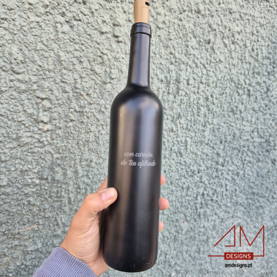 Garrafa preta fosca com texto branco e rolha em cortiça