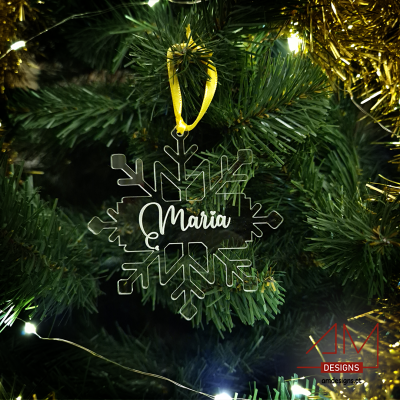 Enfeite de Natal floco de neve transparente com o nome Maria suspenso num pinheiro verde