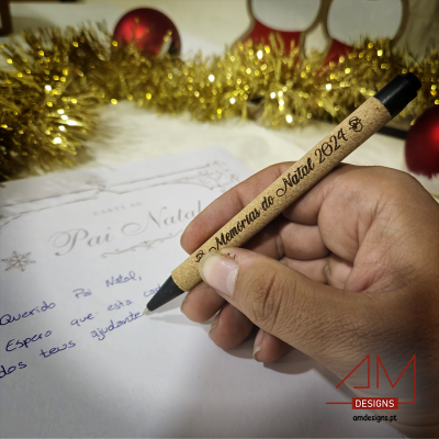 Caneta de madeira gravada 'Memórias do Natal 2024' a escrever carta de Natal com decoração festiva