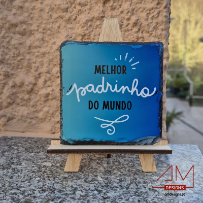 Placa decorativa azul em ardósia com texto sobre um mini cavalete de madeira