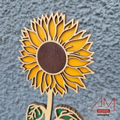 Flor de girassol em madeira recortada e pintada sobre fundo cinza