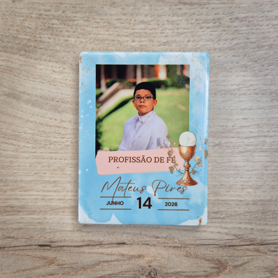 Cartão azul com fotografia de menino em fato branco e texto de profissão de fé e data.