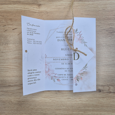 Convite de casamento floral com cartão translúcido e cordão de juta sobre madeira