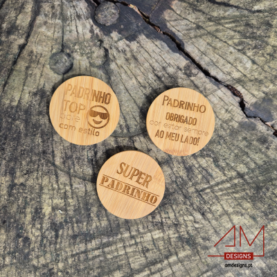 Três discos redondos em madeira com mensagens para padrinhos sobre superfície de madeira escura