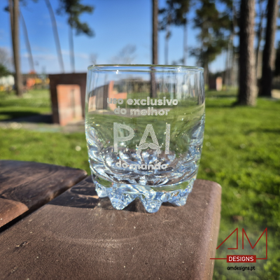 Copo de vidro transparente com texto gravado ao ar livre