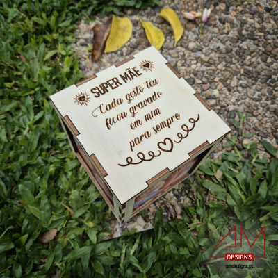 Caixa em madeira clara com gravação para mãe sobre relva e gravilha