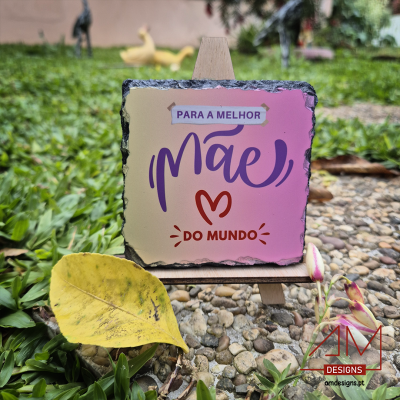 Placa decorativa para mãe com texto sobre suporte de madeira em ambiente exterior com pedras e relva.