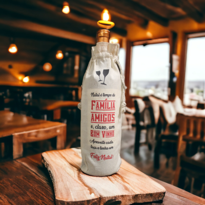 Garrafa de vinho num saco de tecido cinza claro com texto vermelho e preto numa mesa em restaurante rústico