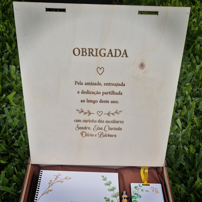 Caixa de madeira com gravação em português e itens de papelaria com tema botânico