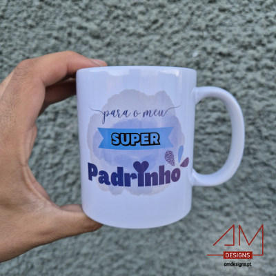 Caneca branca com mensagem para padrinho em diversas cores segurada contra uma parede cinza