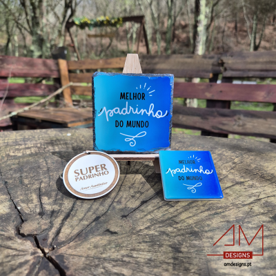 Três artigos azuis e brancos com textos para padrinho sobre mesa de madeira num cenário ao ar livre