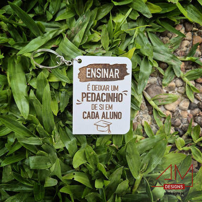 Chaveiro branco com texto motivacional sobre ensino em folhas verdes