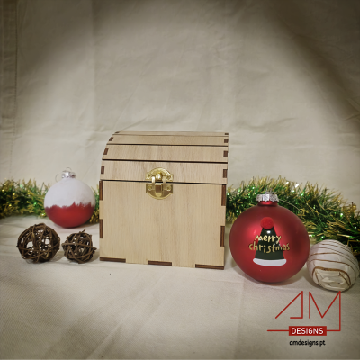 Caixa de madeira clara com fecho dourado e enfeites de Natal ao redor
