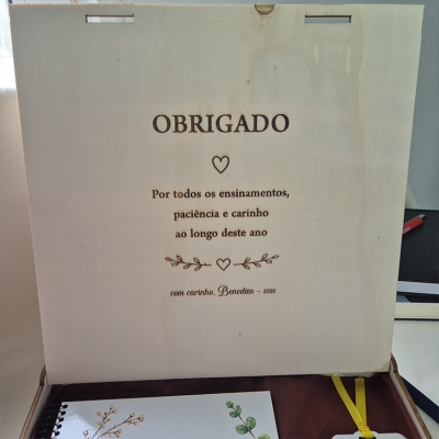 Placa de madeira clara com mensagem gravada a laser em português e decoração com corações e ramos