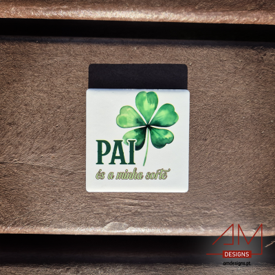 Íman branco com trevo de quatro folhas e texto para pai sobre superfície castanha