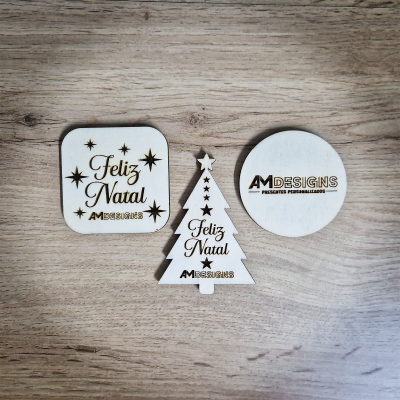 Ornamentos de Natal em madeira com textos 'Feliz Natal' e 'AMDESIGNS'