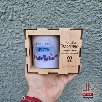 Caneca branca 'SUPER Padrinho' em caixa de madeira clara com texto gravado, segurada à mão