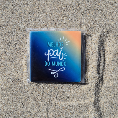 Chapa quadrada com frase MELHOR pai DO MUNDO em degradê azul, verde e laranja sobre areia