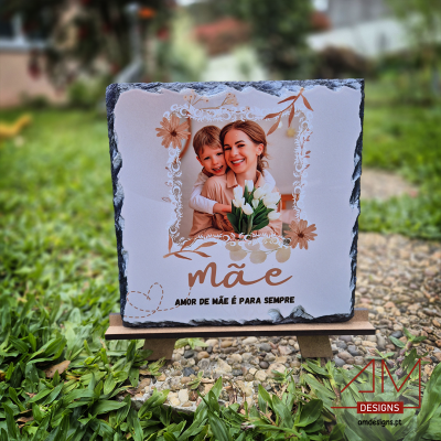 Placa decorativa com foto e texto sobre mãe em cavalete de madeira ao ar livre