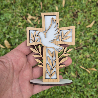 Cruz decorativa em madeira com pomba e folhas sobre fundo branco