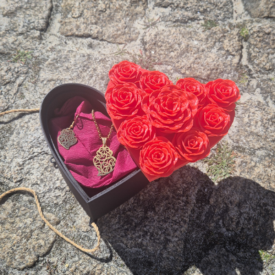 Caixa coração preta com flores vermelhas e joias douradas no interior