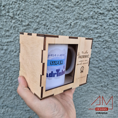 Caixa de madeira com janela transparente mostrando caneca branca com texto e gravação na madeira