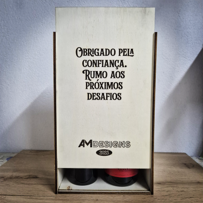 Caixa de madeira clara com texto gravado e duas garrafas na parte inferior