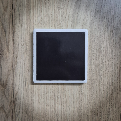 Quadrado preto com moldura branca sobre superfície de madeira clara