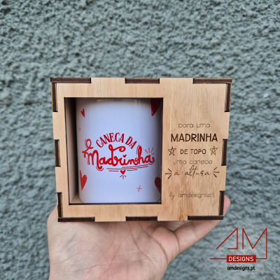 Caneca branca com texto vermelho numa caixa de madeira gravada