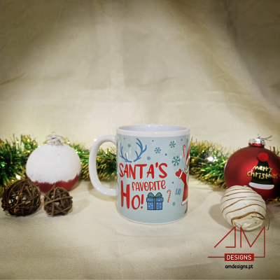 Caneca natalícia com texto e ilustrações coloridas num cenário com bolas de Natal e decoração