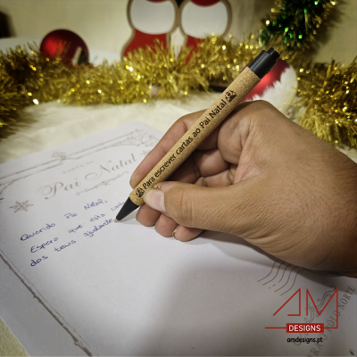 Lápis de madeira castanha clara com texto gravado, usado para escrever carta de Natal, com decoração dourada e vermelha ao fundo.