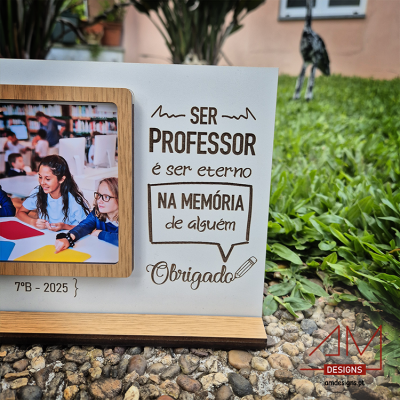 Moldura de madeira com texto de agradecimento a professor e foto de crianças numa sala de aula