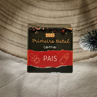 Quadrado decorativo com texto '2025 Primeiro Natal como PAIS' em fundo preto e vermelho.