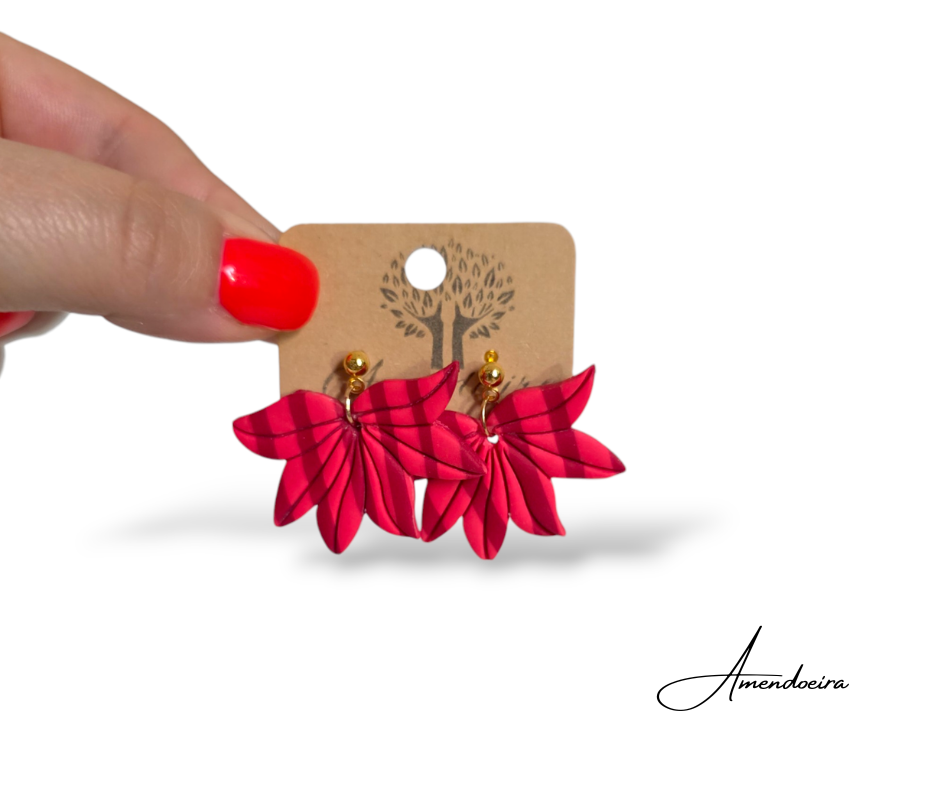 Brincos Flor Rubi - Riscas rosa e bordeaux Brincos vermelhos em forma de folhas com detalhes dourados em cartão castanho