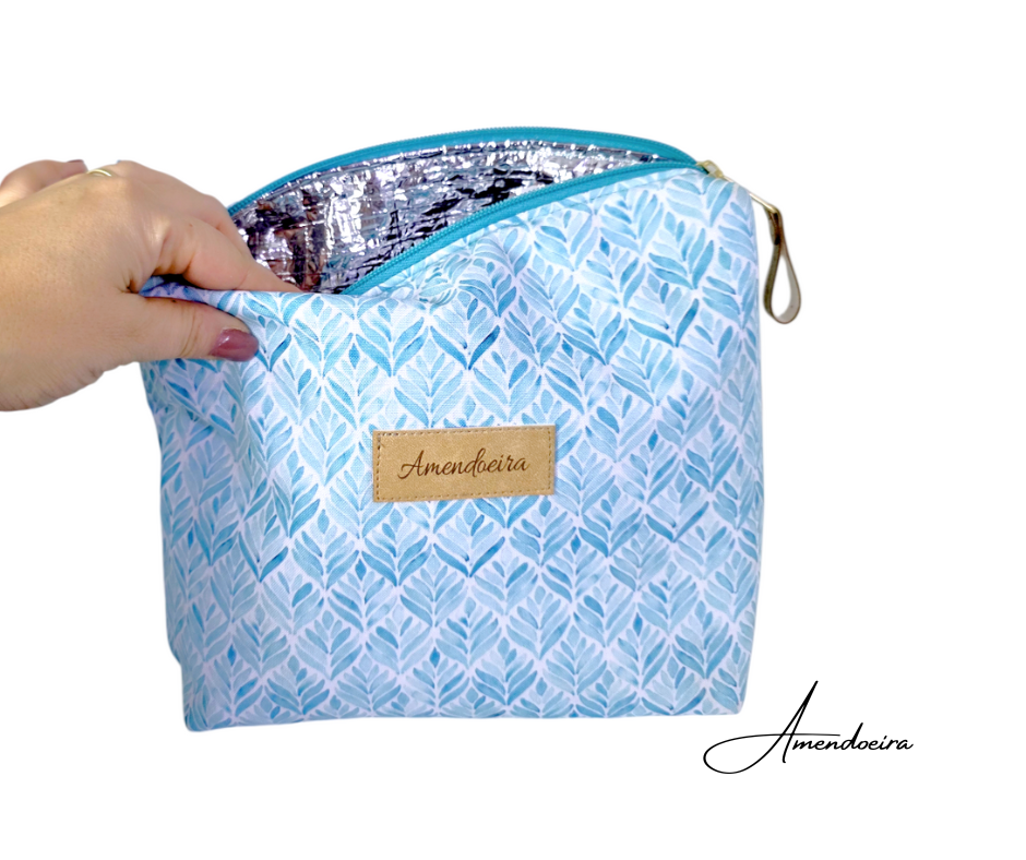 Lancheira/ Bolsa térmica- Folhas azuis Bolsa térmica azul com padrão de folhas e interior prata isolante com etiqueta Amendoeira.