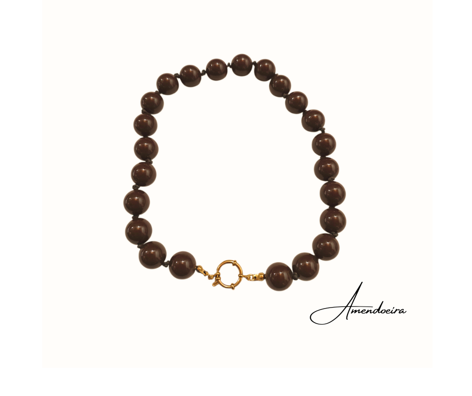 Colar Terra serena Colar de esferas castanhas com fecho dourado em fundo branco e texto Amendoeira