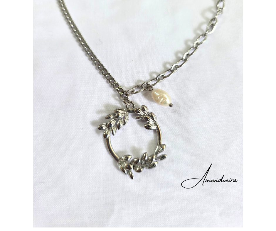 Colar Coroa de Louros com Pérola Colar prateado com pendente circular e pérola sobre fundo branco com palavra Amendoeira