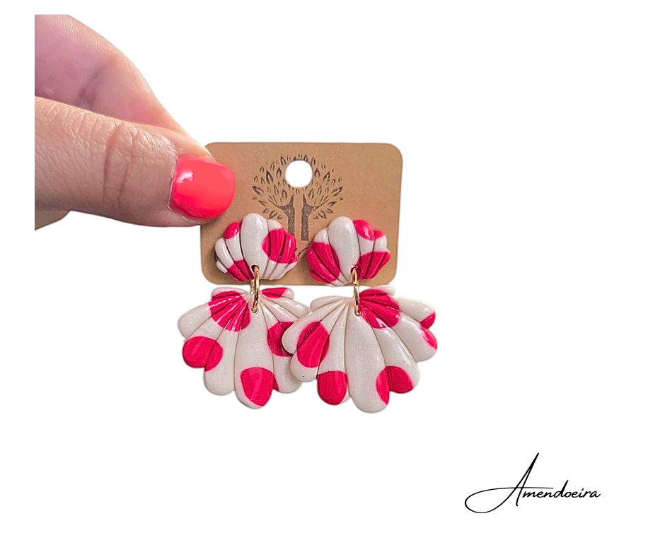 Brincos Marcarena - Bolas rosa cereja Brincos florais creme e rosa em suporte castanho segurado por mão com unhas pintadas de rosa