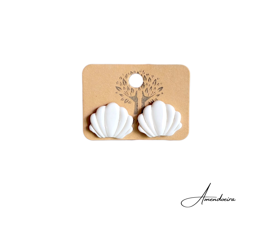Brincos Sea - Branco Brincos em forma de concha branca sobre cartão castanho com desenho de árvore