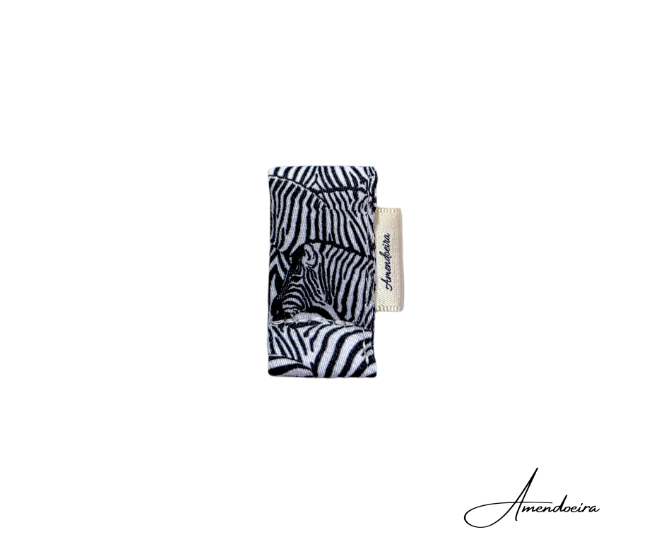 Separador magnético Livro/Agenda - Zebra Produto têxtil com padrão zebra e etiqueta Amendoeira sobre fundo branco