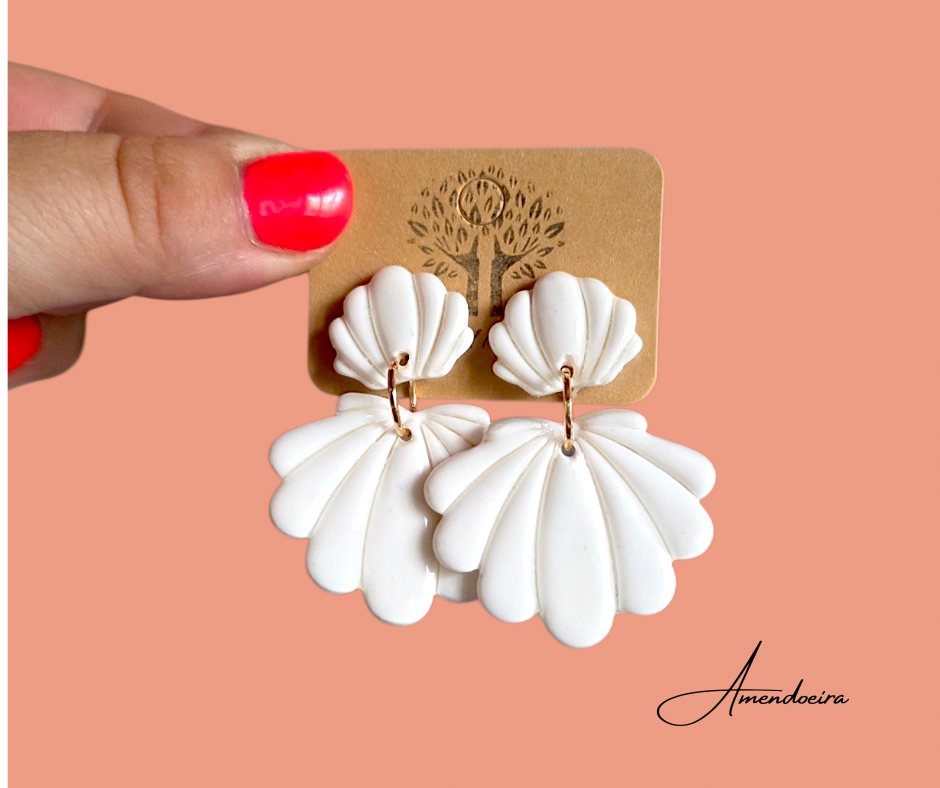 Brincos Marcarena - Branco Brincos de resina branca em forma de concha com cartão castanho e fundo laranja