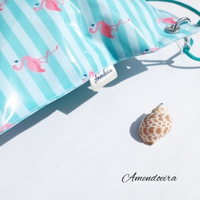 Bolsa azul e branca com padrão de flamingos e concha ao lado