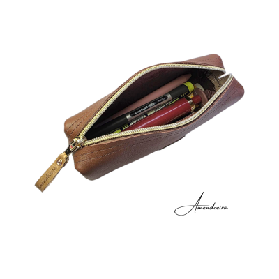 Estojo castanho com caneta, lápis e batom, fecho dourado, fundo branco