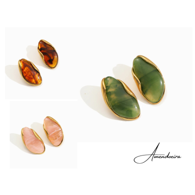 Três pares de brincos dourados com pedras âmbar, verde e rosa em fundo branco