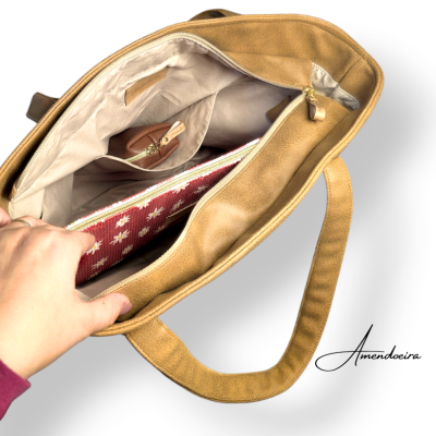 Bolsa amendoada aberta com interior forrado bege, carteira vermelha com flores brancas e pequena necesseire castanha