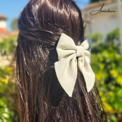 Laço bege de tecido em cabelo castanho escuro