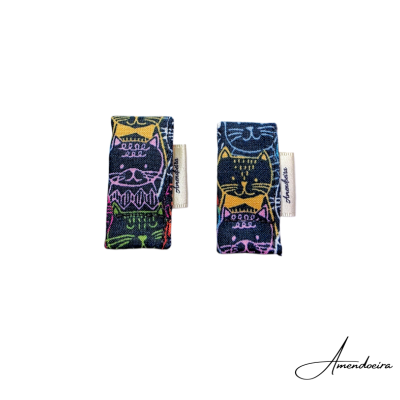 Dois clips de tecido com estampado de gatos coloridos em fundo azul escuro