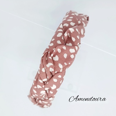 Toca de cabeça castanho rosado com manchas brancas e nó frontal