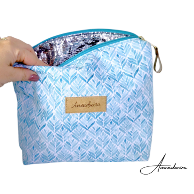 Bolsa térmica azul com padrão de folhas e interior prata isolante com etiqueta Amendoeira.