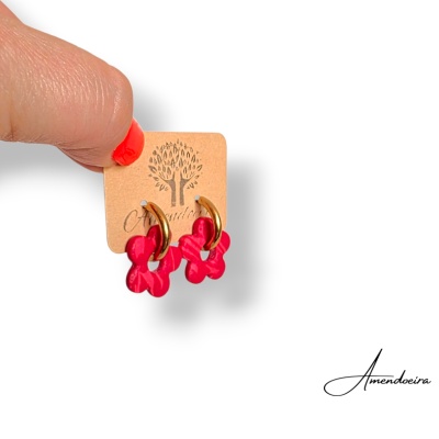 Brincos com argola dourada e flor vermelha pendente em cartolina com logótipo
